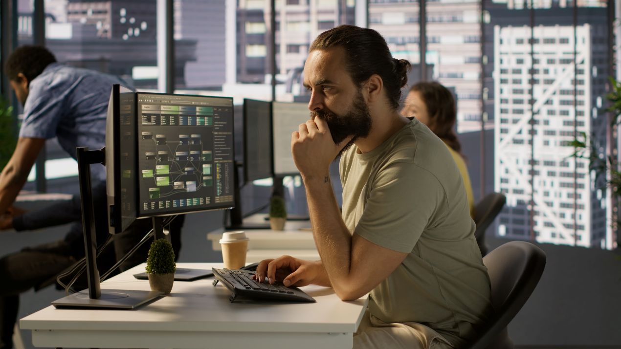 Mitarbeiter richtet Software Musikfachhandel am Arbeitsplatz ein, unterstützt durch technische Integration und Support im Hintergrund